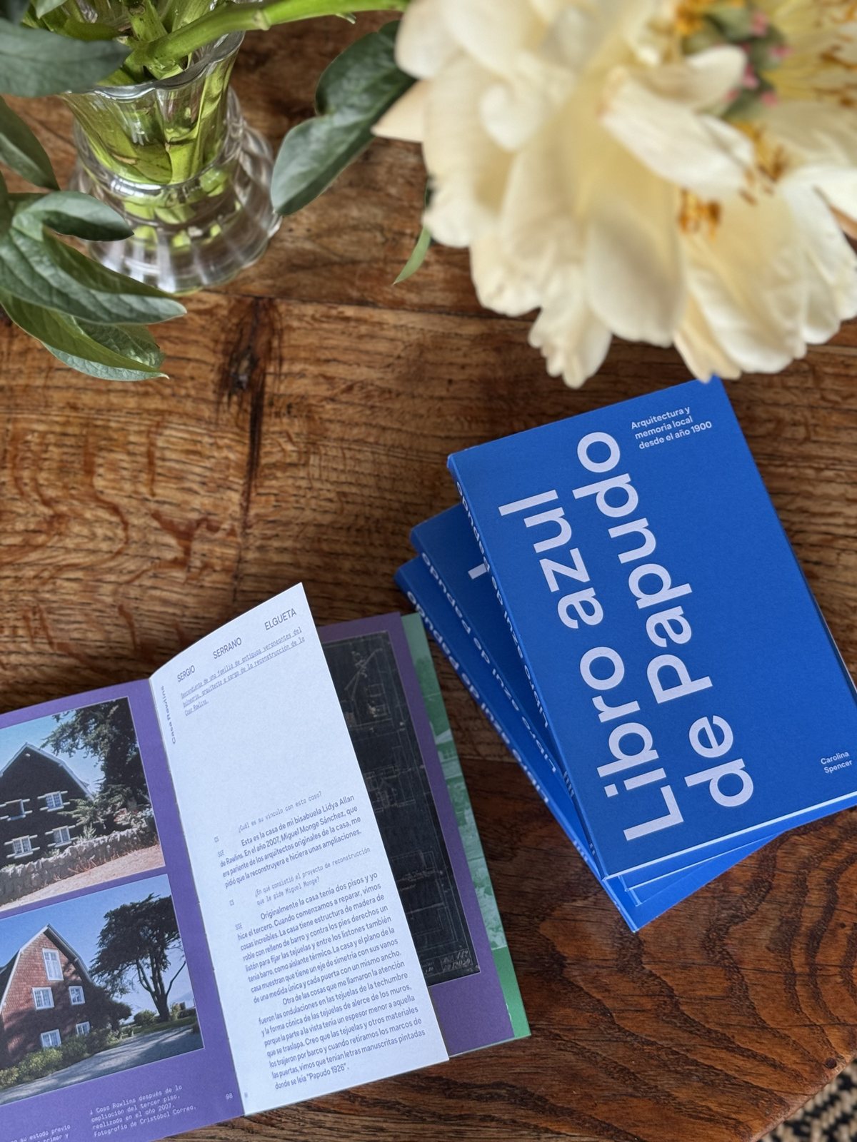 Libro azul de Papudo sobre una mesa con flores